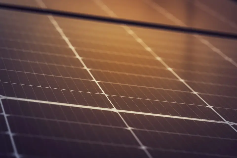 De cellen en lijnen van een zonnepaneel van dichtbij, in warm avondlicht